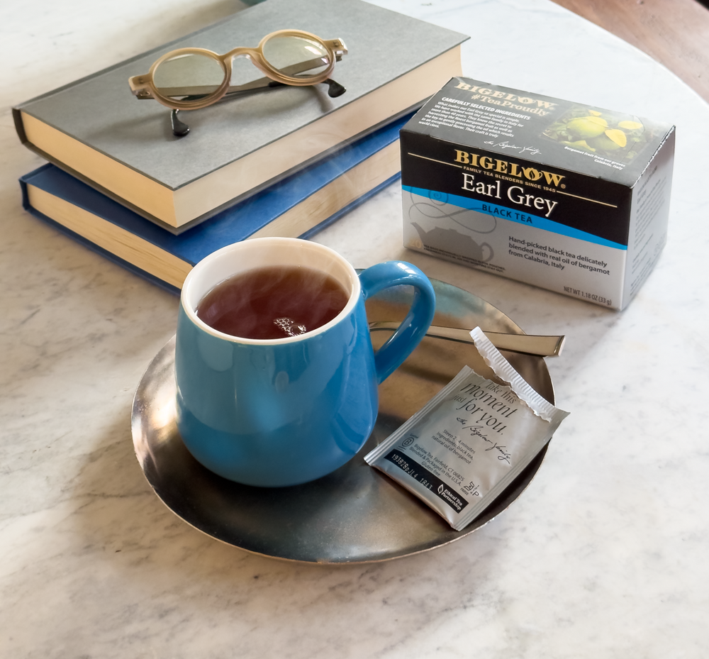 Books with a mug of Bigelow Earl Grey Tea